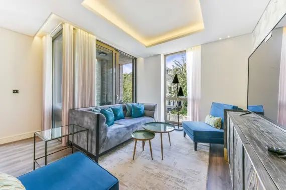 The living room boasts a light and modern aesthetic, with sleek furnishings and a luxurious design