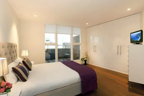 A spacious and bright bedroom with balcony access