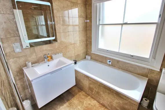 Step into the classic porcelain-tiled room with a deluxe walk-in rain shower and slipper bath in the Arlington bathroom