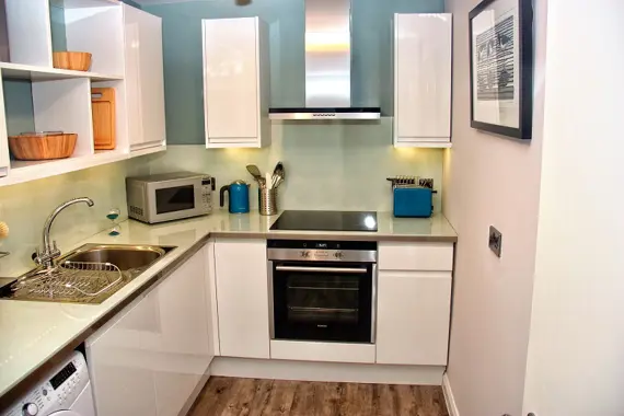 The stylish kitchen offers integrated appliances, bright and bold accents and a contemporary glass splash back make it a pleasure to cook in