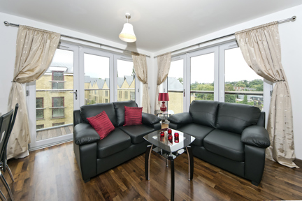 An open plan living area at Kings Island with large windows and comfortable sofas