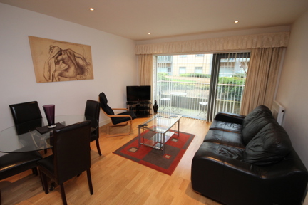 A modern, spacious living and dining area in a one bedroom apartment