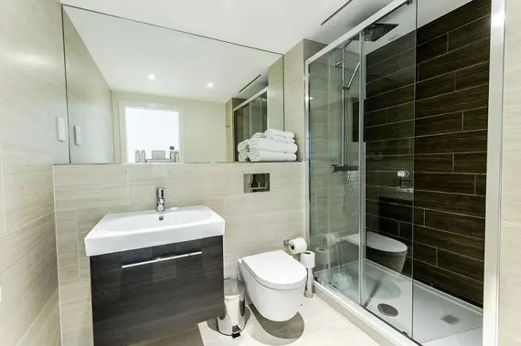 A crisp, clean shower room in a one bedroom apartment