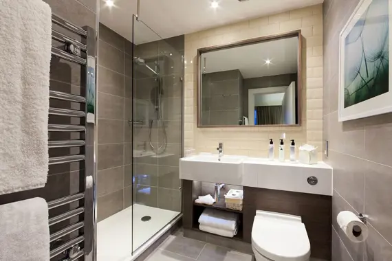 A sleek, shiny shower room in a studio apartment