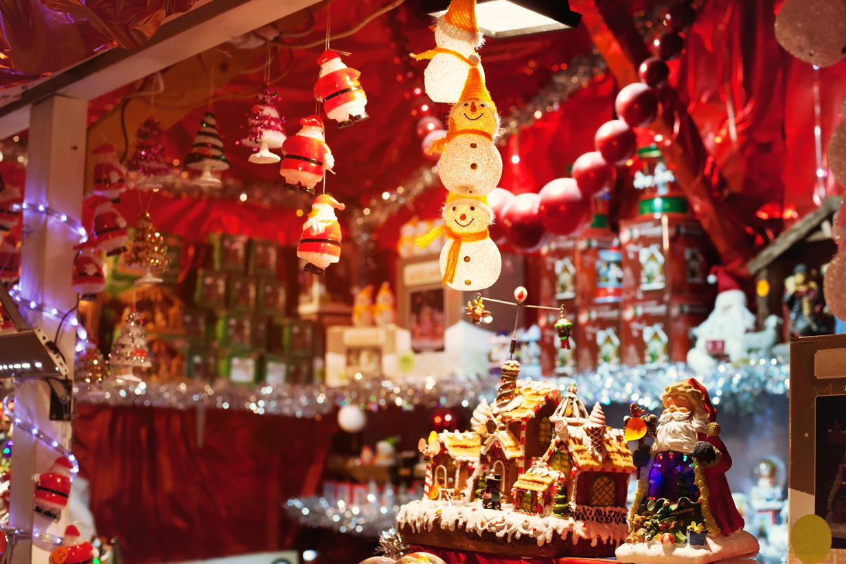a christmas market hut lit up at night with hanging snowman figures